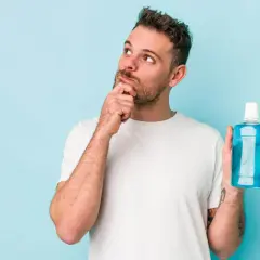 Hombre pensativo con enjuague bucal, ¿será la solución para una infección?