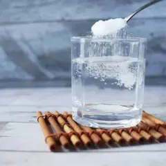 Cuchara añade sal a un vaso de agua, remedio casero para aliviar las encías inflamadas.