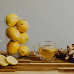 Jarra con limones, taza de té con rodaja de limón y jengibre. Una bebida refrescante para combatir el aliento ácido.