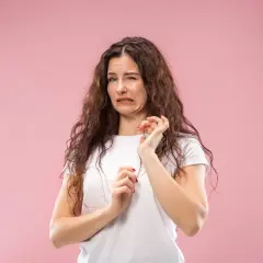 Mujer con expresión de desagrado, como si tuviera la boca salada. Podría ser por algo que comió o por deshidratación.