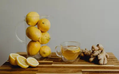 Jarra con limones, taza de té con rodaja de limón y jengibre. Una bebida refrescante para combatir el aliento ácido.