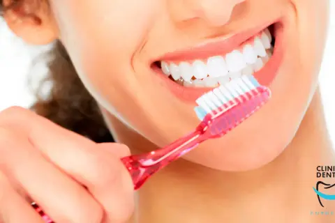 Una mujer se cepilla los dientes con una sonrisa radiante. Con un cepillado diario, se puede quitar una caries y mantener una boca sana.