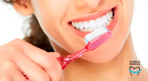Una mujer se cepilla los dientes con una sonrisa radiante. Con un cepillado diario, se puede quitar una caries y mantener una boca sana.