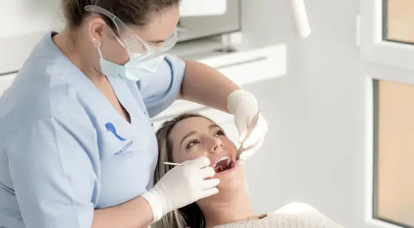 Dentista realiza limpieza de dientes a paciente.