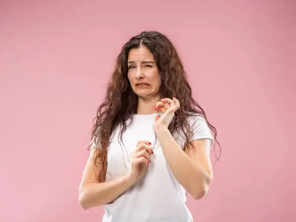 Mujer con expresión de desagrado, como si tuviera la boca salada. Podría ser por algo que comió o por deshidratación.